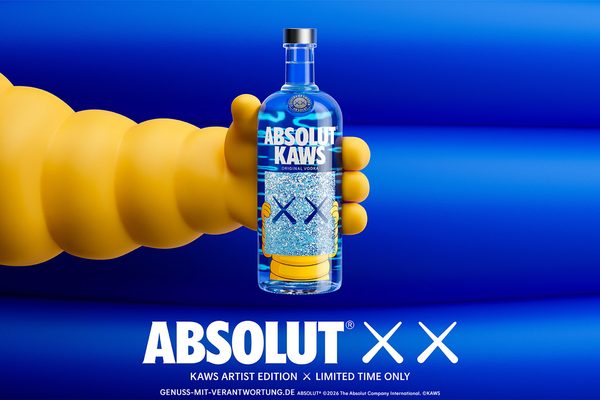 Absolut KAWS eine gelbe Hand hält eine Flasche Absolut KAWS vor einem blauen Hintergrund