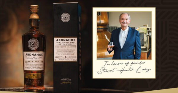 Ardnahoe Chairman's Selection und Stewart Laing eine Flasche Whisky mit Geschenkverpackung in der Linken, in der Rechten ein Foto eines Mannes