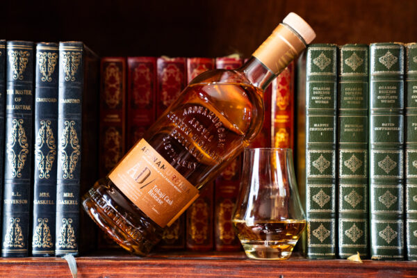 eine Flasche Ardnamurchan AD/ Tokaji Cask Release samt Glas in einem Bücherregal