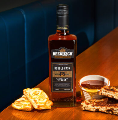 eine Flasche Beenleigh Double Cask Master 5 Blends nebst Speisen auf einem Tisch