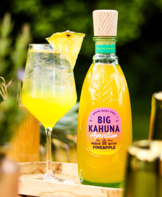Big Kahuna Aperitivo das Foto zeigt eine Flasche Big Kahuna Aperitivo nebst Glas auf einem Holzbrett