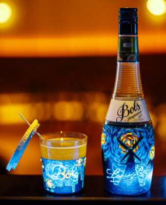 das Foto zeigt den Drink "Neon Hydra", daneben eine Flasche