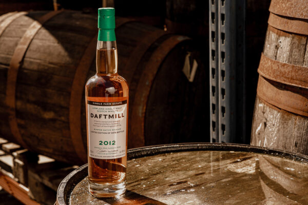 eine Flasche Daftmill 2012/2026 Winter Batch Release steht auf einem Holzfass
