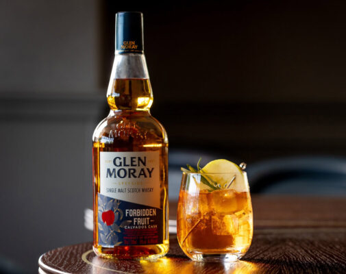 eine Flasche Glen Moray Forbidden Fruit nebst Glas auf einem Tisch