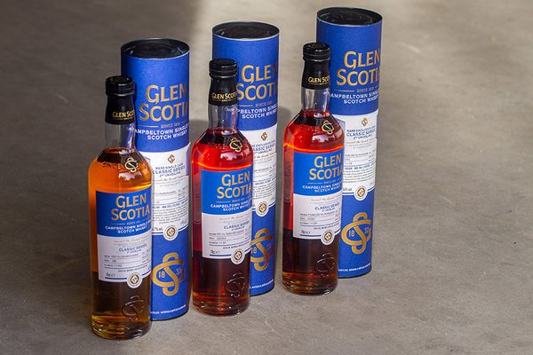 Glen Scotia Classic Series 2nd Unveiling drei Flaschen Whisky samt Geschenkhüllen stehen auf einem Betonboden