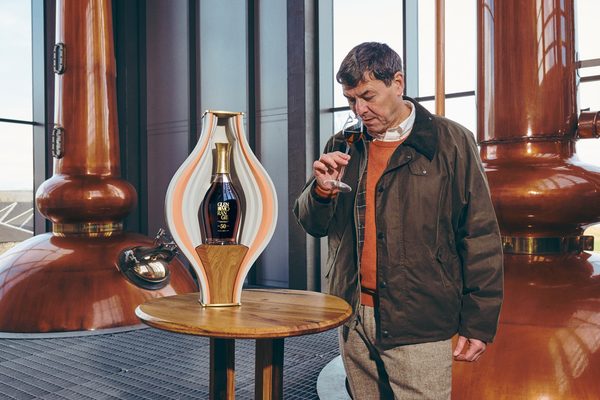 Glenmorangie 50 Jahre eine Flasche Glenmorangie 50 Jahre in einer Keramik auf einem Tisch in einer Brennerei. Daneben ein Mann