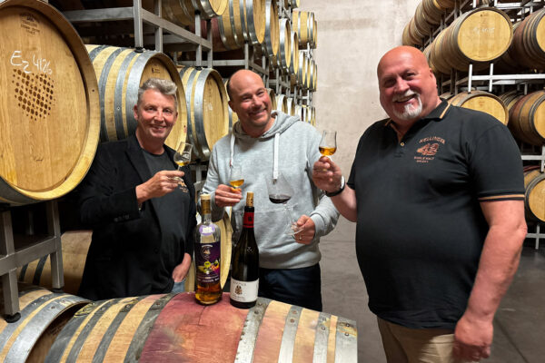 Hellinger 42 Deutsche Winzeredition VDP-Weingut Knipser drei Männer stehen in einem Fasslager um ein Fass mit Whisky und Wein in den Händen