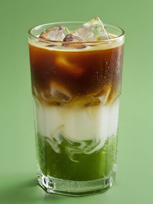 Dirty Matcha Latte der Drink "Dirty Matcha Latte" vor grünem Grund