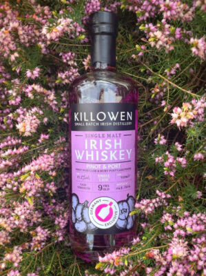 eine Flasche Killowen Single Malt Pinot & Port 9 Jahre liegt in einem Strauch