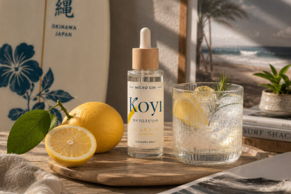 Koyi Micro Gin Lemon eine Flasche Koyi Micro Gin Lemon nebst einer Zitrone und einem Glas auf einem Holzbrett auf einem Holztisch