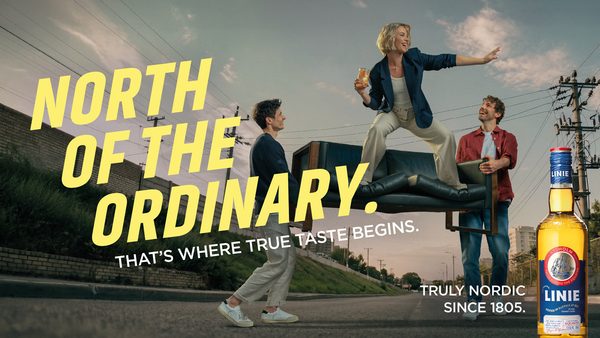 „North of the Ordinary“ by Linie Aquavit eine Frau steht auf einer von zwei Männern gehaltenen Couch auf einer Straße, davor Text, in einer Ecke eine Flasche Linie Aquavit