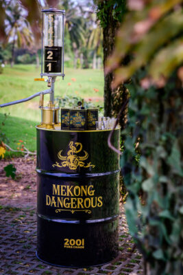 Mekong Dangerous Coffee Spirit mehrere Dosen Mekong Dangerous Coffee Spirit auf einer Tonne, die über eine Handpumpe verfügt