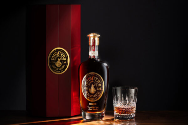 eine Flasche Michter's Celebration Sour Mash 2025 Release neben einem Glas und einer Geschenkhülle