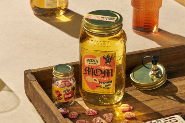 eine Einmachglas O'Donnell Moonshine Pfirsich Best Mom Edition nebst eines kleinen Glases Kirschbonbons in einem Holzrahmen