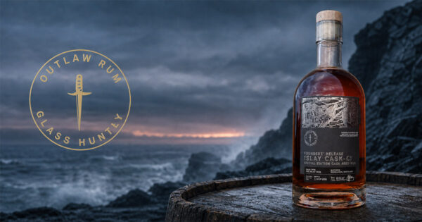 Outlaw Rum Founders’ Release Islay Cask-CI eine Flasche Outlaw Rum Founders’ Release Islay Cask-CI steht auf einem Holzfass an einer Klippe