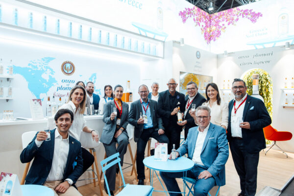 das Foto zeigt Menschen an einem Messestand von Ouzo Plomari