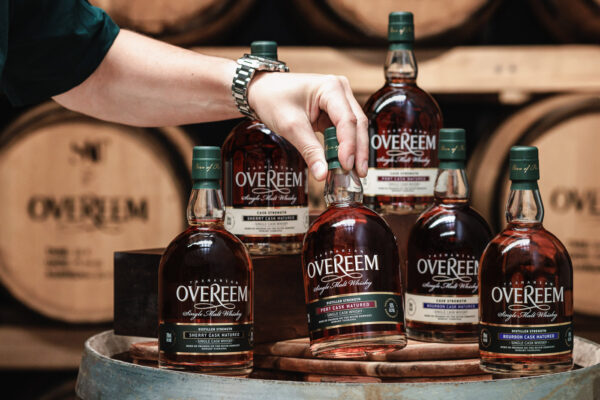 Overeem Core Range diverse Flaschen Overeem Single Malt stehen auf einem Holzfass