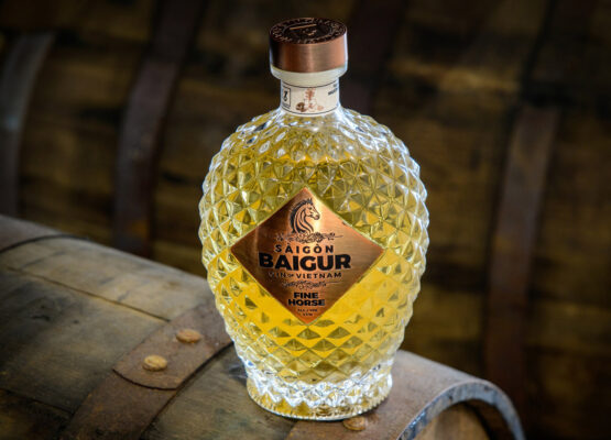 Saigon Baigur Fine Horse Gin das Foto zeigt eine Flasche Saigon Baigur Fine Horse Gin auf einem Holzfass
