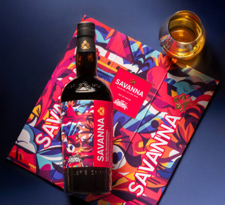 Savanna Art of Rum by Xandro eine Flasche Savanna Art of Rum by Xandro liegt auf der Geschenkverpackung, daneben ein Glas