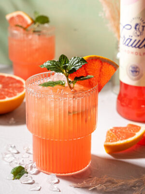 Virgin Pink Mojito ein Glas "Virgin Pink Mojito", im Hintergrund eine Flasche Schlitzer Fräulein Alkoholfrei