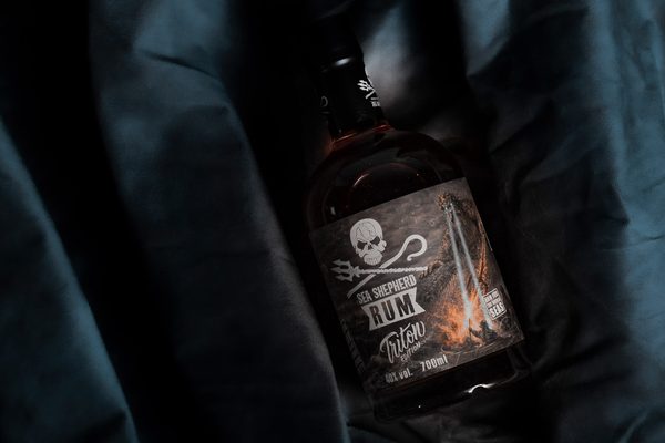 Sea Shepherd Rum Triton Edition eine Flasche Sea Shepherd Rum Triton Edition liegt auf einem dunkelblauen Tuch