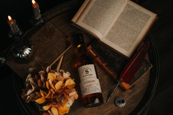 Signatory Vintage Clynelish 2013/2026 eine Flasche Signatory Vintage Clynelish 2013/2026 liegt samt Büchern und Kerzen auf einem Holzfass