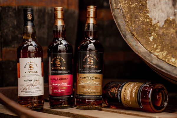 Signatory Vintage Neuheiten das Foto zeigt vier Flaschen Whisky, umgeben von Holzfässern