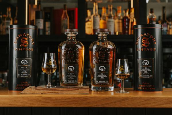 Signatory Vintage 50th Anniversary of Kirsch Import zwei Flaschen Whisky samt Gläser und Geschenkhülle auf einem Bartresen