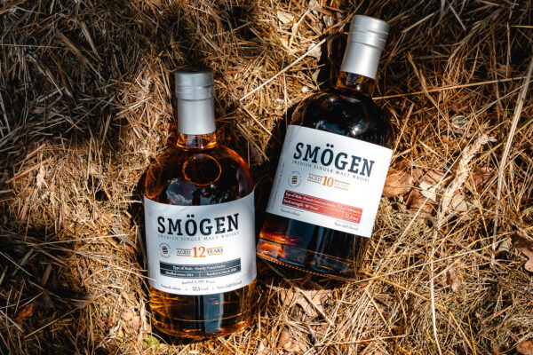 Smögen 10 Jahre Peated Oloroso Sherry Hogsheads und Smögen 12 Jahre zwei Flaschen Whisky liegen im Stroh