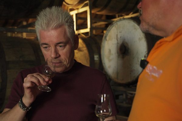 Michael Mittermeier eine Mensch riecht an einem Glas Whisky innerhalb eines Fasslagers