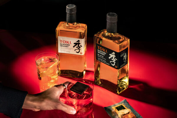 das Foto zeigt je eine Flasche Suntory Toki und Suntory Toki Black. Davor zwei Drinks