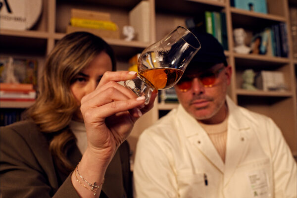 Kelsey McKechnie und Daniel Arsham das Foto zeigt zwei Menschen, die ein Glas Whisky betrachten