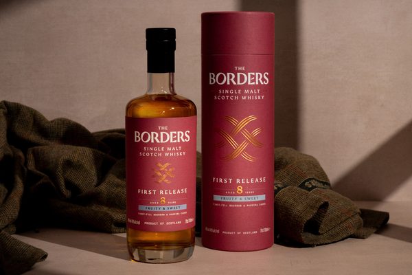 The Borders First Release 8 Jahre eine Flasche The Borders First Release 8 Jahre nebst Geschenkhülle vor einer Tweed-Jacke