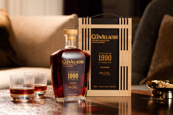 The GlenAllachie 1990 35 Jahre eine Flasche The GlenAllachie 1990 35 Jahre steht neben einer Holzbox und zwei Gläsern auf einem Holztisch