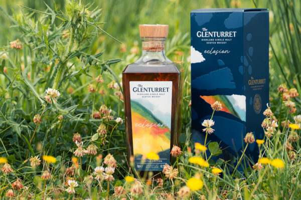 The Glenturret Eclosion eine Flasche The Glenturret Eclosion samt Geschenkverpackung steht im hohen Gras