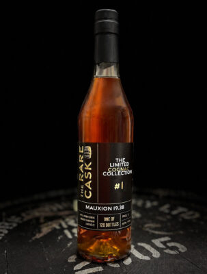 The Rare Cask Cognac Mauxion 19.38 eine Flasche Cognac steht auf einem Holzfass