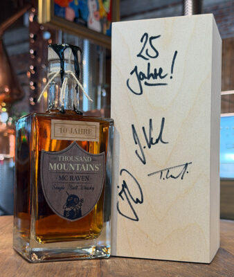 Thousand Mountains Mc Raven 10 Jahre eine Flasche Whisky neben einer Holzkiste
