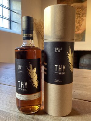 Thy Whisky Single Cask #1912 - Oloroso eine Flasche Thy Whisky Single Cask #1912 - Oloroso nebst Geschenkhülle auf einem Holztisch in einem Zimmer
