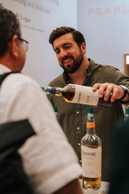 Whisky Live Germany 2026 ein Mensch schenkt einem anderen einen Whisky in ein Glas