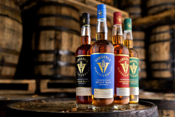 das Foto zeigt aufgereiht die American Single Malts der Virginia Distillery auf einem Holzfass in einem Fasslager