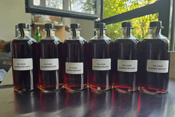 Wagemut PX-Cask Kleiner Bruder sechs Flaschen stehen auf einem Metalltisch