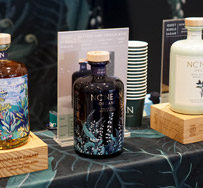 das Foto zeigt Flaschen an einem Messestand