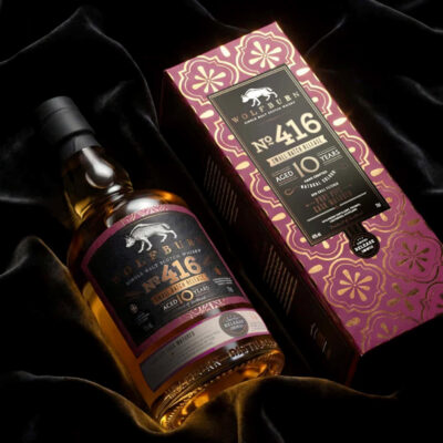 Wolfburn Small Batch No. 416 eine Flasche Wolfburn Small Batch No. 416 nebst Geschenkverpackung liegt auf einem dunklen Tuch